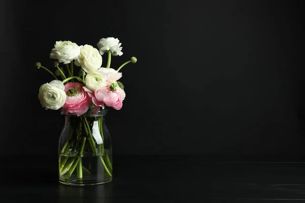 Glazen vaas met mooie ranunculus bloemen op zwarte achtergrond — Stockfoto