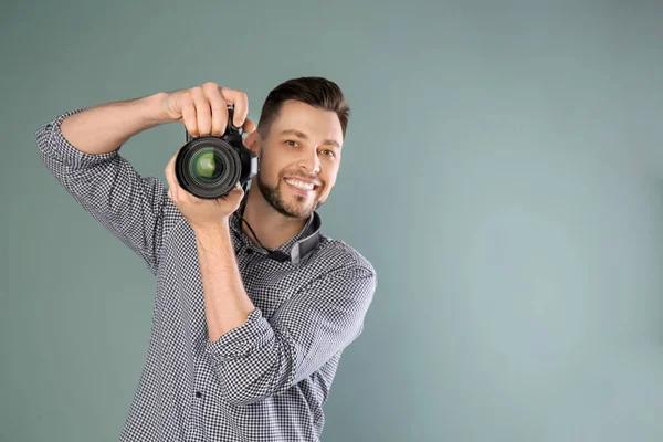 Mężczyzna fotograf z aparatem na szarym tle — Zdjęcie stockowe