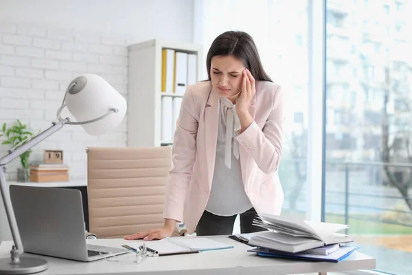 Giovane donna che soffre di mal di testa in ufficio — Foto Stock