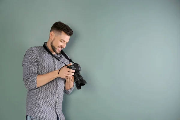 Männlicher Fotograf mit Kamera auf grauem Hintergrund — Stockfoto