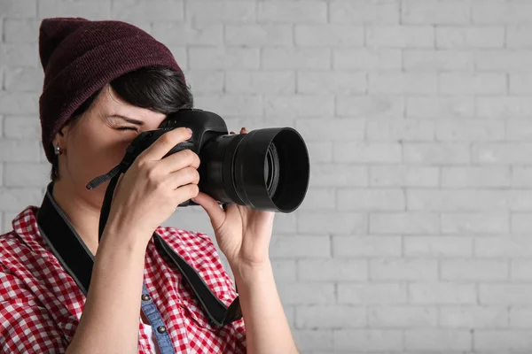 レンガの背景にカメラで若い女性写真家 — ストック写真