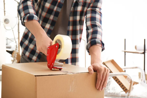 Young man packing moving box indoors, closeup — Stock Photo, Image