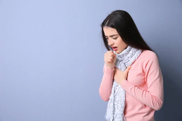 Mujer joven tosiendo sobre fondo de color — Foto de Stock