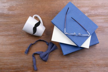 Kupası bıyık, papyon ve ahşap zemin üzerine kitaplar. Babalar günü kutlama