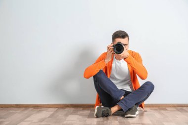 Kamera ışık duvarının yakınında ile erkek fotoğrafçı