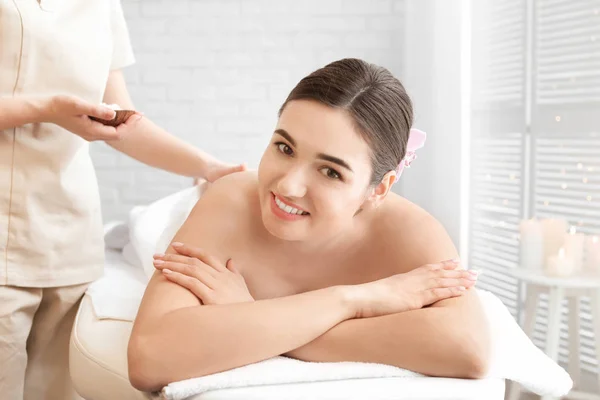 Jovem mulher tendo procedimento de limpeza corporal com sal marinho no salão de spa — Fotografia de Stock
