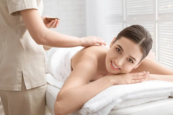 Young woman having body scrubbing procedure with sea salt in spa salon — Stock Photo, Image