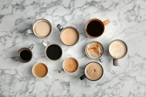 Muitas xícaras de café quente aromático diferente na mesa de mármore — Fotografia de Stock