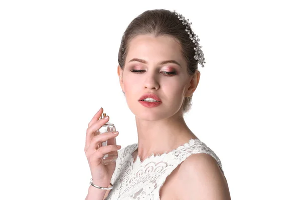 Bella giovane sposa con bottiglia di profumo su sfondo bianco — Foto Stock