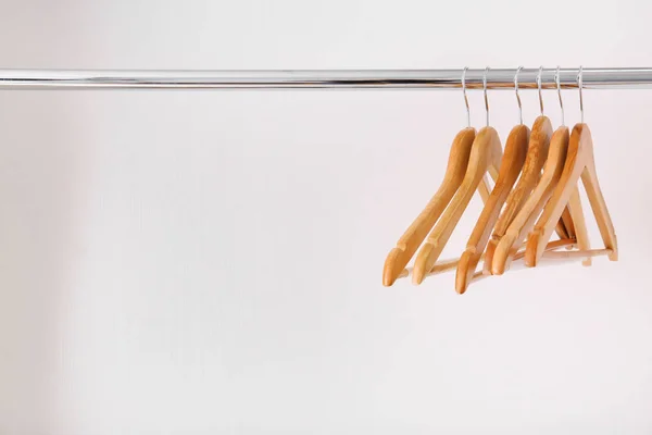 Clothes rail with wooden hangers on white background