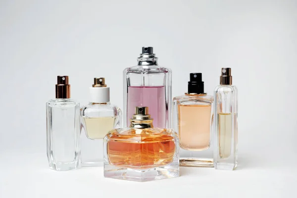 Genomskinliga flaskor parfym på vit bakgrund — Stockfoto