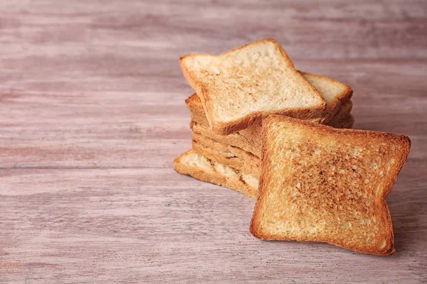 Ízletes pirított kenyér, fából készült háttér — Stock Fotó