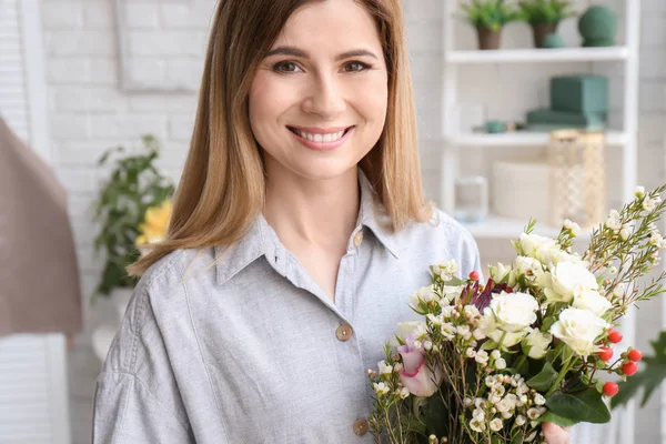 Vrouwelijke bloemist met prachtige boeket op werkplek — Stockfoto