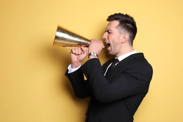 Joven gritando en megáfono sobre fondo de color — Foto de Stock