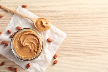 Kavanoz ve kaşık krem fıstık ezmesi masada