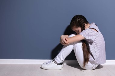 Depresif küçük kız kapalı yere oturma. Çocuk psikologu ziyaret etmek için zaman