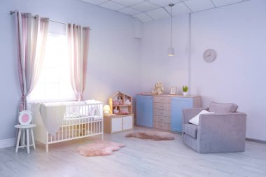 Bebek odasının içinde rahat bir beşik ve koltuk var.
