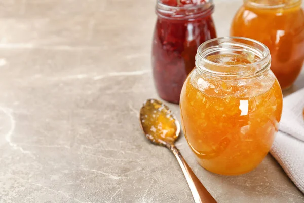 Gläser mit verschiedenen süßen Marmeladen auf dem Tisch — Stockfoto