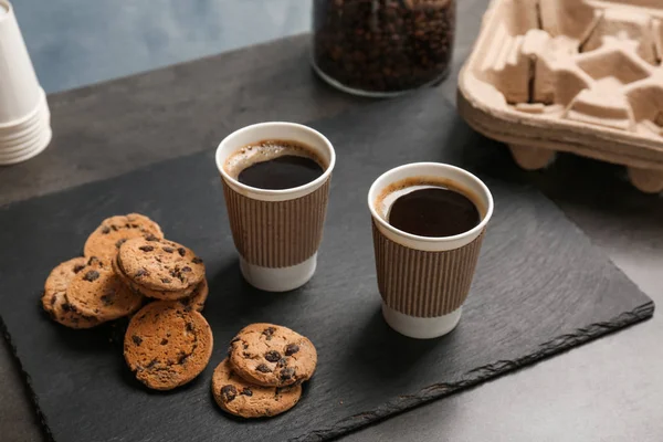 Composição com café quente aromático em copos de papel e biscoitos na mesa — Fotografia de Stock