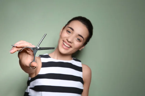 Professionele kapper met een schaar op kleur achtergrond — Stockfoto