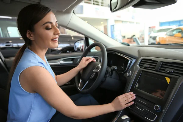 サロンで新しい車の運転席に座っていた若い女性 — ストック写真