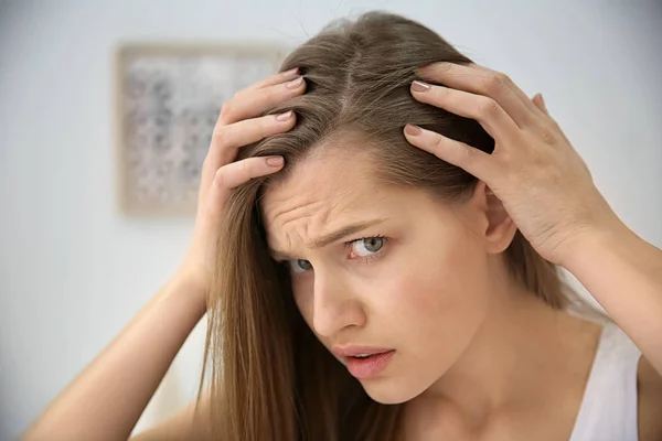 Mujer joven con problemas de pérdida de cabello en interiores —  Fotos de Stock