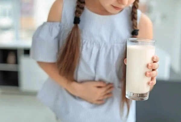 乳品过敏小女孩在室内举行牛奶玻璃 — 图库照片