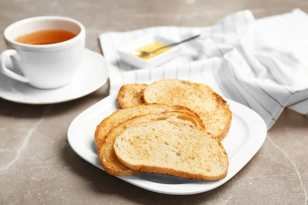 Płyta z tosty z chleba i filiżankę herbaty na szarym tle — Zdjęcie stockowe