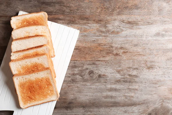 Panneau avec pain grillé sur fond bois, vue de dessus — Photo