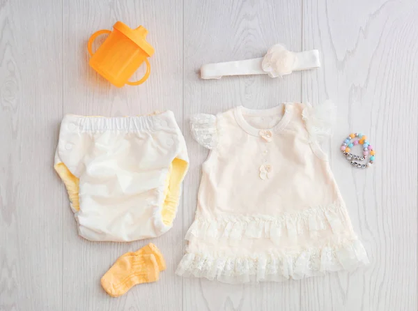 Composição de leigos plana com roupas infantis na moda em fundo de madeira — Fotografia de Stock