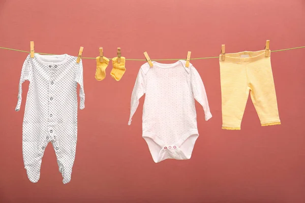 Ropa para niños en la línea de lavandería contra el fondo de color — Foto de Stock