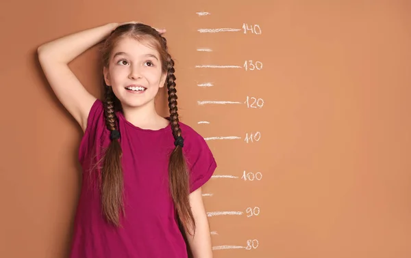 Маленькая Девочка Измеряет Свой Рост Цветном Фоне — стоковое фото