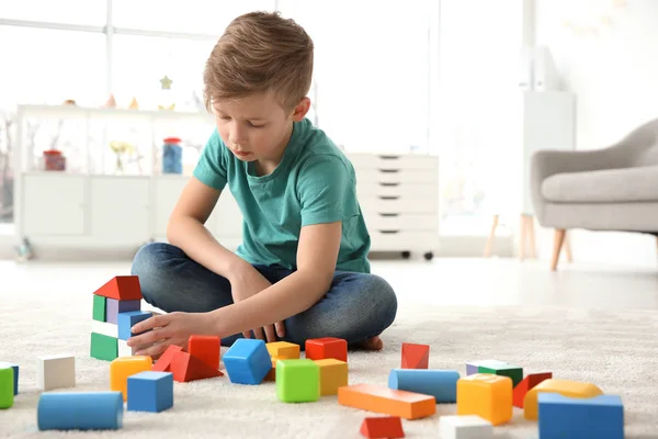 Liten autistisk pojke leker med kuber hemma — Stockfoto