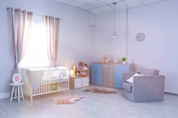 Интерьер детской комнаты с удобной кроваткой и креслом — стоковое фото