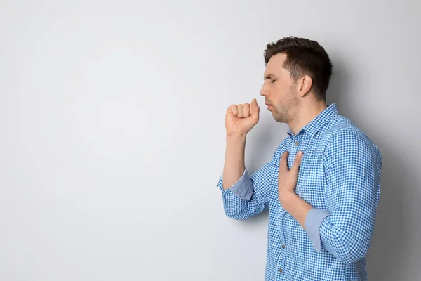 Joven tosiendo sobre fondo claro — Foto de Stock