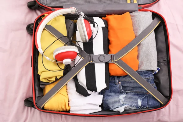 Valigia da viaggio aperta con cose imballate sul letto, vista dall'alto — Foto Stock