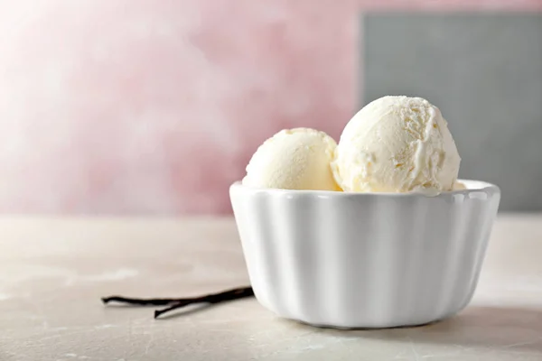 Tigela com saboroso sorvete de baunilha na mesa — Fotografia de Stock