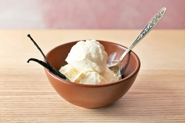 Cuenco con sabroso helado de vainilla sobre mesa de madera — Foto de Stock