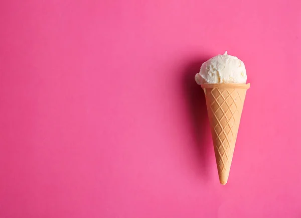 Cono de gofre con sabroso helado de vainilla sobre fondo de color — Foto de Stock