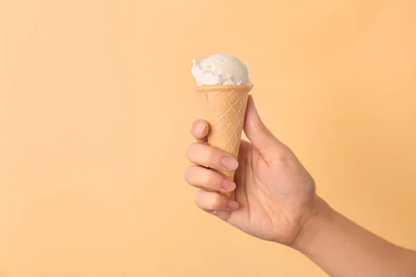 Mulher segurando cone waffle com saboroso sorvete de baunilha no fundo de cor — Fotografia de Stock