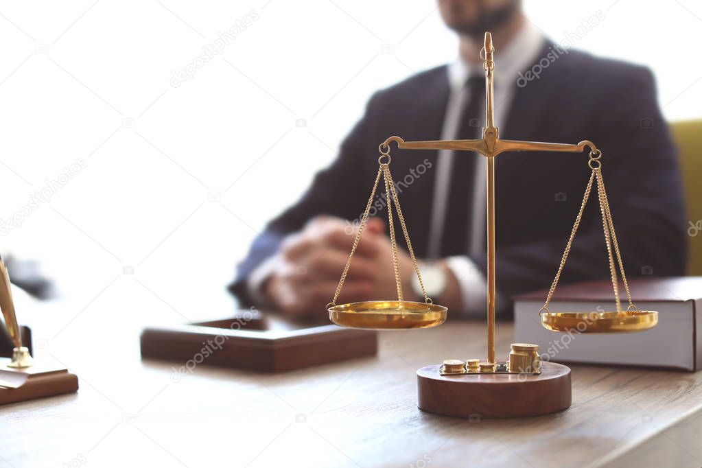Scales on table and lawyer in office