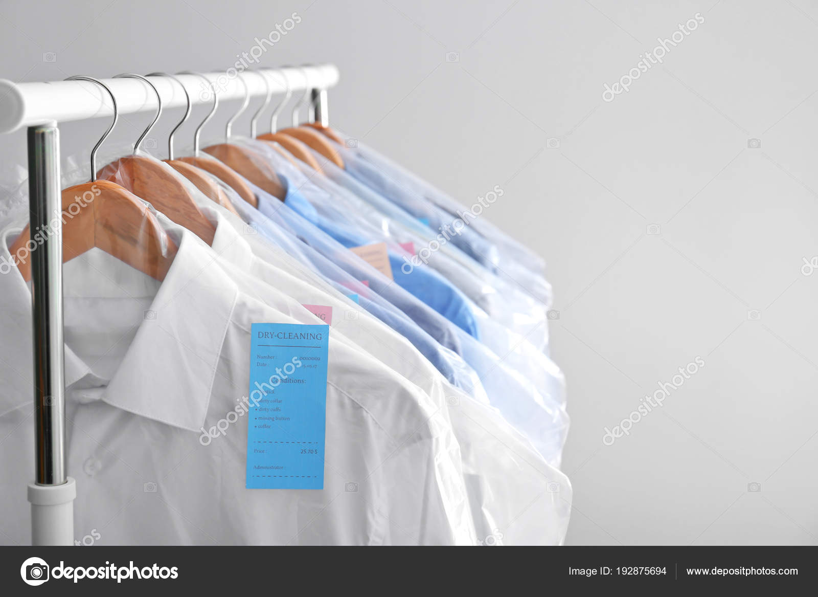 Rack with clean clothes on hangers after dry-cleaning against light  background Stock Photo by ©NewAfrica 192875694