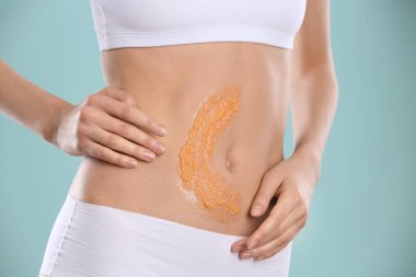 Genç kadının karnı renk arka plan, closeup karşı doğal fırçalayın uygulayarak