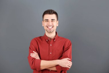 Gri arka plan üzerinde büyüleyici genç adam