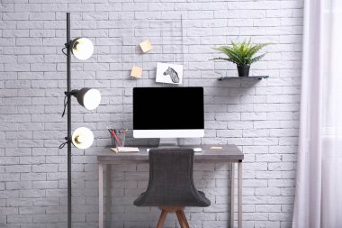 Ev ofisindeki masada bilgisayarla rahat bir iş yeri.