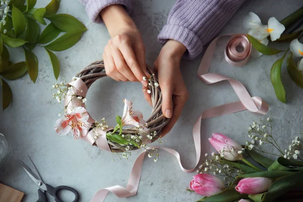 Female decorator creating beautiful wreath at table, top view — Stock Photo, Image