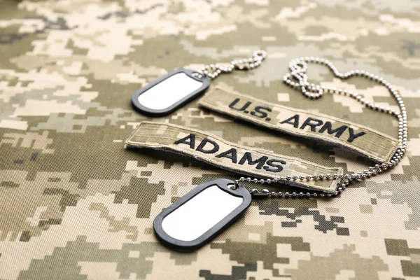 Military ID tags and patches on camouflage background — Stock Photo, Image