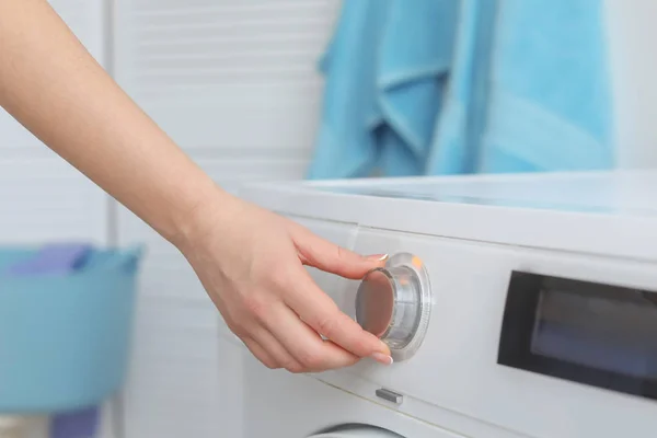 Молода жінка робить прання вдома, крупним планом — стокове фото