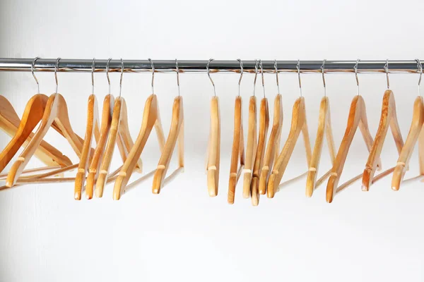 Trilho de roupas com cabides de madeira no fundo branco — Fotografia de Stock