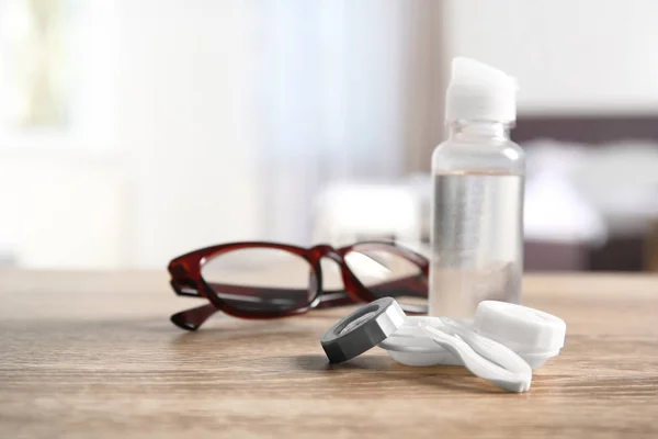 Caixa da lente de contato, pinças, garrafa de solução e óculos na mesa — Fotografia de Stock